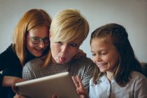 Mãe e suas filhas tomando selfie com tablet digital em casa — Fotografia de Stock