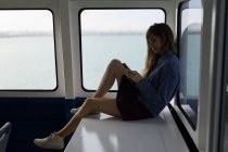 Beautiful woman using mobile phone in cruise ship — Stock Photo