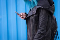 Mid section of woman with backpack using mobile phone — Stock Photo