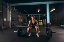 Fit femme levant le haltère dans la salle de gym — Photo de stock