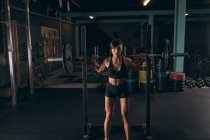 Fitte Frau beim Anheben der Langhantel im Fitnessstudio — Stockfoto