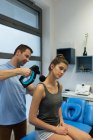 Fisioterapista che fa un massaggio alla donna in clinica — Foto stock