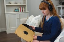 Femme détenant un record de vinyle dans le salon à la maison — Photo de stock