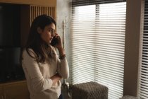 Жінка розмовляє по мобільному телефону вдома — стокове фото