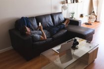 Homem usando telefone celular na sala de estar em casa — Fotografia de Stock