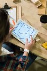 Feminino carpinteiro olhando para o plano em tablet digital na oficina — Fotografia de Stock
