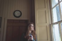 Задумчивая женщина пьет черный кофе дома — стоковое фото