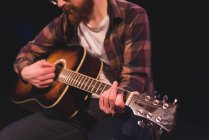 Hombre tocando la guitarra en el escenario en el teatro - foto de stock