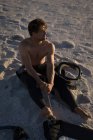 Surfista maschio che prepara un aquilone su una spiaggia al crepuscolo — Foto stock