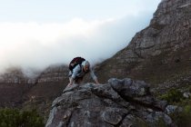 Hombre mayor escalando montaña rocosa en el campo - foto de stock