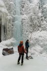 Coppia in piedi insieme vicino montagna rocciosa durante l'inverno — Foto stock
