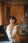 Thoughtful woman having coffee in kitchen at home — Stock Photo