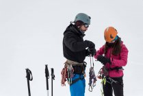Paar trägt im Winter Gurtzeug auf einem schneebedeckten Berg — Stockfoto