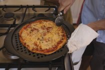 Uomo che prepara pizza in cucina a casa, cucina casalinga — Foto stock