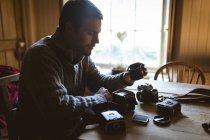 Homem reparando uma câmera vintage em casa — Fotografia de Stock