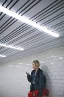Jovem usando telefone celular no metrô — Fotografia de Stock