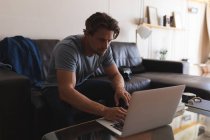 Mann benutzt Laptop im heimischen Wohnzimmer — Stockfoto