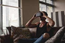 Mann benutzt Virtual-Reality-Headset im heimischen Wohnzimmer — Stockfoto