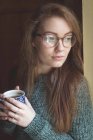 Задумчивая женщина пьет черный кофе дома — стоковое фото