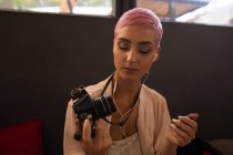 Mulher elegante segurando câmera no restaurante — Fotografia de Stock