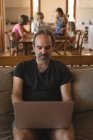 Homme utilisant un ordinateur portable dans le salon à la maison — Photo de stock