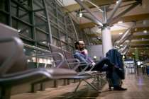 Pensativo hombre de negocios esperando en la sala de espera en el aeropuerto - foto de stock