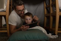 Батько з сином використовує цифровий планшет вдома — стокове фото