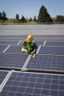 Чоловік працює на сонячних панелях на сонячній станції в сонячний день — стокове фото