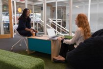 Молодые женщины-руководители взаимодействуют друг с другом в офисе — стоковое фото