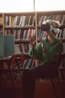Молода жінка використовує гарнітуру віртуальної реальності в бібліотеці — стокове фото
