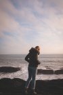Вид сзади на женщину, стоящую на пляже — стоковое фото