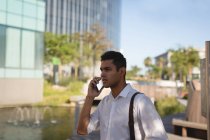 Молодий бізнесмен розмовляє по мобільному телефону в офісних приміщеннях — стокове фото