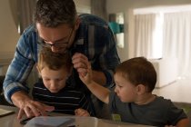 Father and his sons using digital tablet at home — Stock Photo
