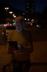Seniorin nutzt nachts digitales Tablet in der Stadt — Stockfoto