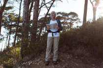 Seniorwanderer steht mit Karte im Wald auf dem Land — Stockfoto