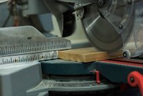 Шліфувальна машина для різання шматка деревини в майстерні — стокове фото
