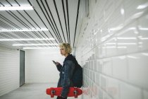 Молода жінка використовує мобільний телефон у метро — стокове фото