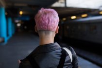 Вид ззаду стильна жінка, що йде на платформі на залізничному вокзалі — стокове фото