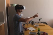 Homme utilisant casque de réalité virtuelle à la maison — Photo de stock