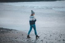 Frau geht in der Dämmerung am Strand spazieren — Stockfoto