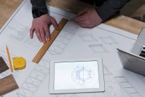 Плотник-мужчина рисует график на картотеке в мастерской — стоковое фото