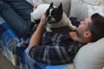 Homme avec bouledogue français chien dans à la maison au lit — Photo de stock