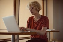 Жінка використовує ноутбук в кафетерії в університеті — стокове фото