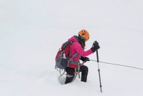 Mulher montanhista andando na região nevada durante o inverno — Fotografia de Stock