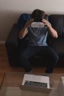 Homme utilisant casque de réalité virtuelle dans le salon à la maison — Photo de stock