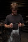 Nachdenklicher Schmied trägt Schürze in Werkstatt — Stockfoto