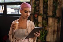 Stilvolle Frau beim Kaffee mit digitalem Tablet im Restaurant — Stockfoto