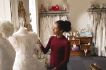 Молода жінка дивиться на весільну сукню в бутіку — стокове фото