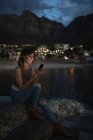 Junge Frau benutzte Handy am Felsenbad — Stockfoto
