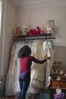Mulher selecionando vestido de noiva de cabides de roupas na boutique — Fotografia de Stock